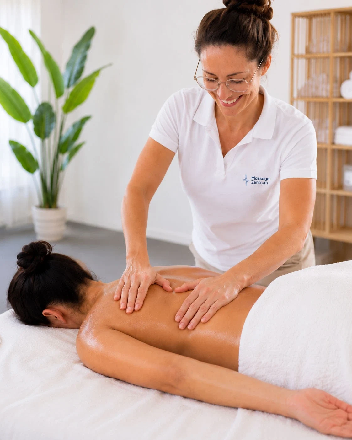 Medizinische Massage: Therapeut behandelt gezielt die Rückenmuskulatur einer Person